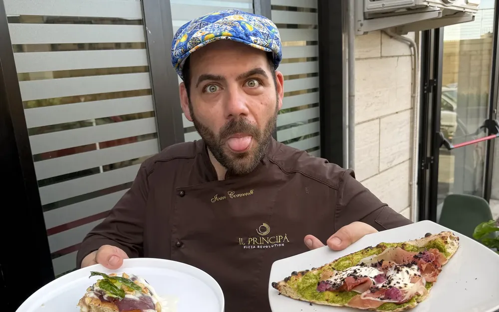 Ivan Correnti con la coppola siciliana e due piatti in mano