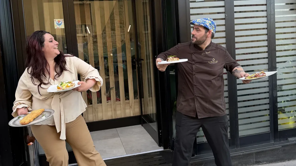 I titolari scherzano davanti alla vetrina della pizzeria